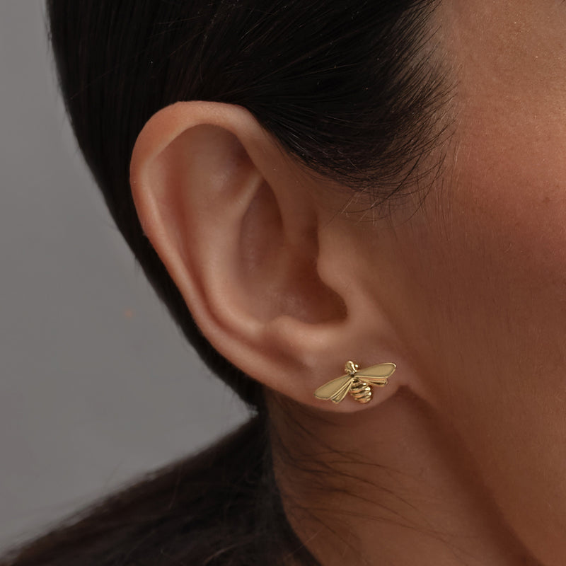 woman wearing gold Olivia Burton Bee earrings