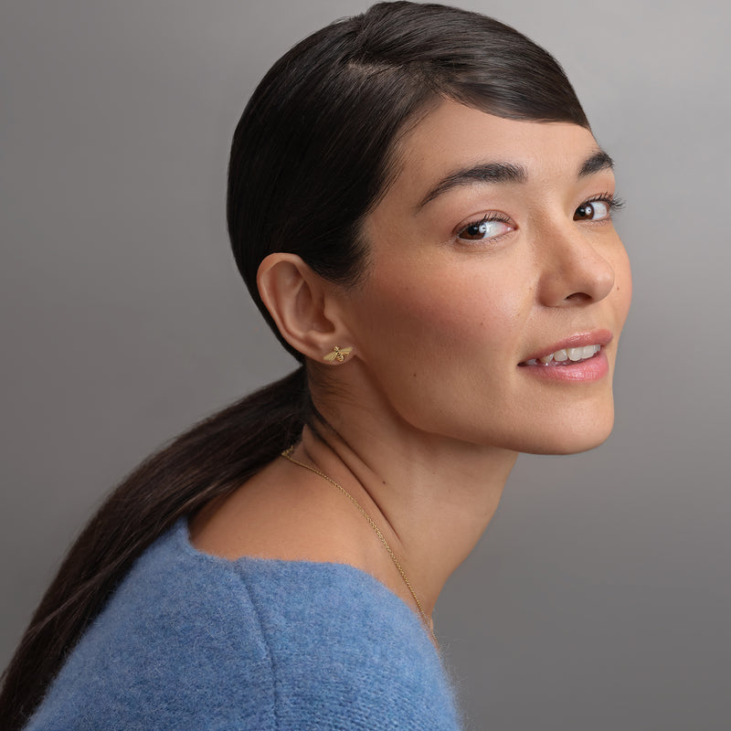 Model wearing Olivia Burton Signature Honey Bee stud earrings - gold plated