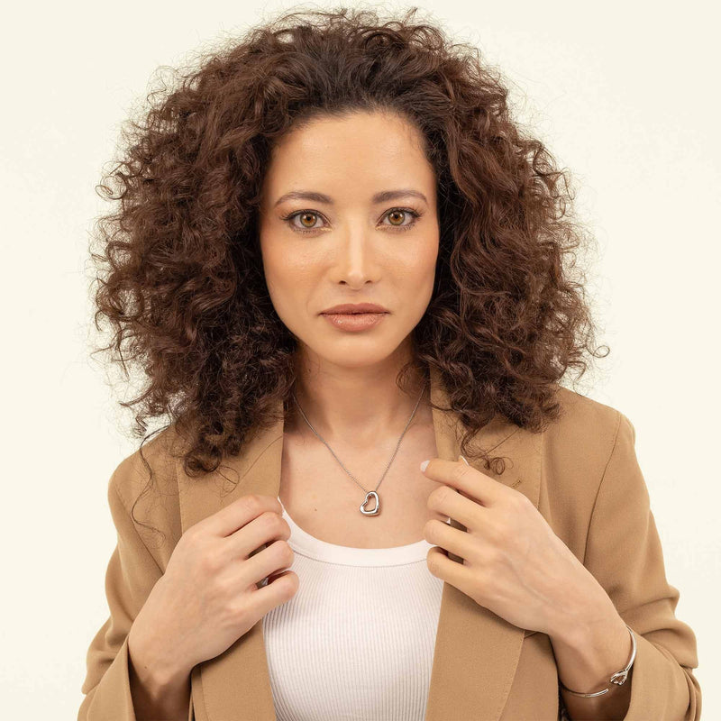 Woman wearing a BOSS heart pendant necklace. Jewelry product shot for detail and style showcase.