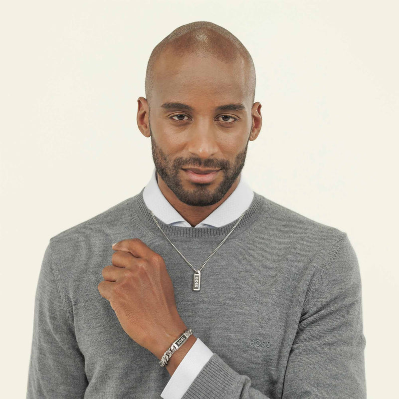 Man wearing a BOSS bracelet and necklace, showcasing the stainless steel jewelry design and polished finish.