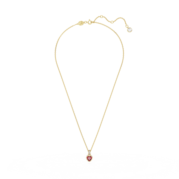 Swarovski Stilla heart pendant in red crystal and gold-plated setting, displayed on a gold chain necklace.