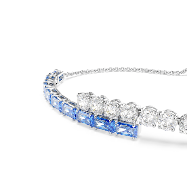 Showcasing the Swarovski Matrix bangle featuring blue mixed-cut crystals and rhodium plating. Close-up of the bangle's