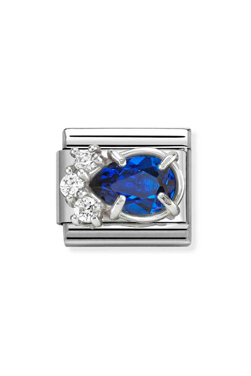 Silver charm with a blue teardrop gem and small white jewels.
