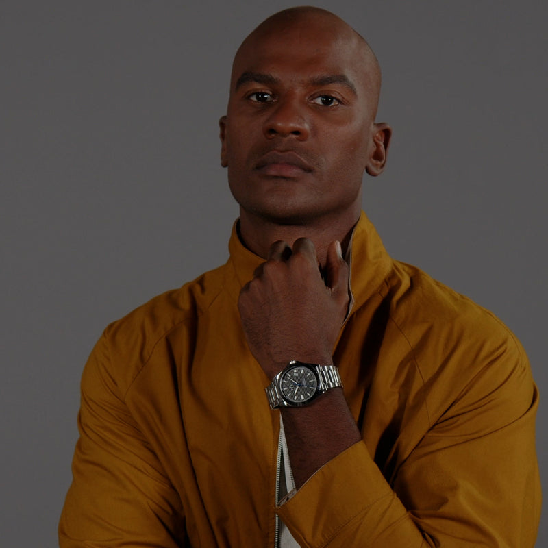 Man wearing BOSS Strike watch, showcasing dial and stainless steel band. Stylish wrist accessory.