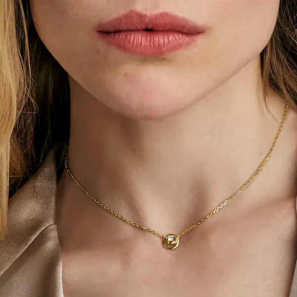 Nomination Cosmiclove necklace on model; gold chain with cubic zirconia circle pendant. Elegant jewelry.